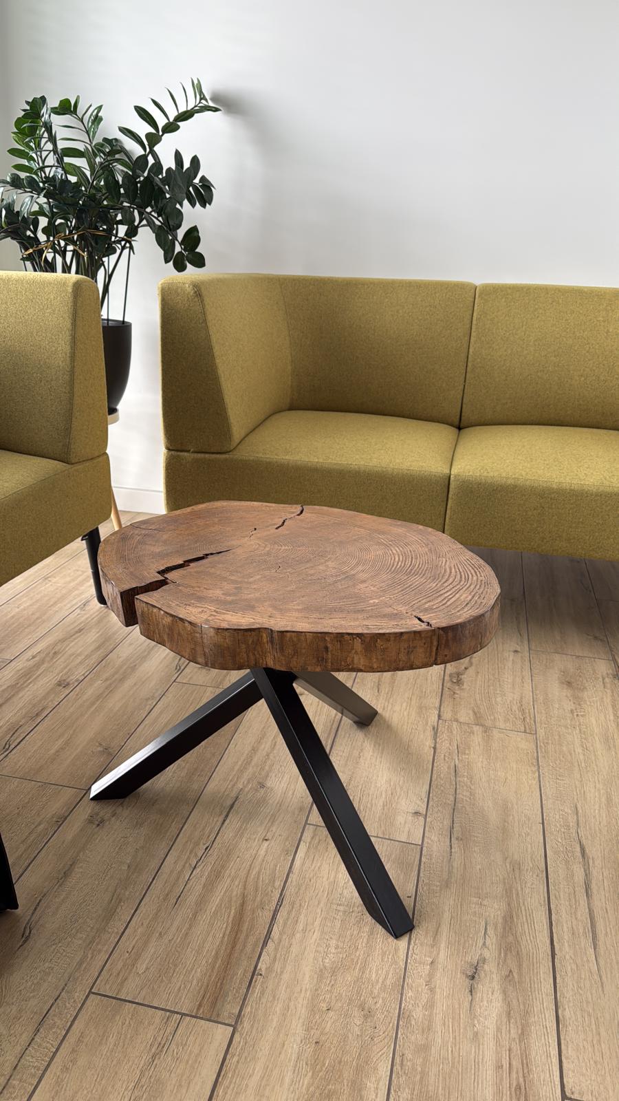 Stolik live edge — plaster drewna na trójnogu, w salonie z żółtą kanapą